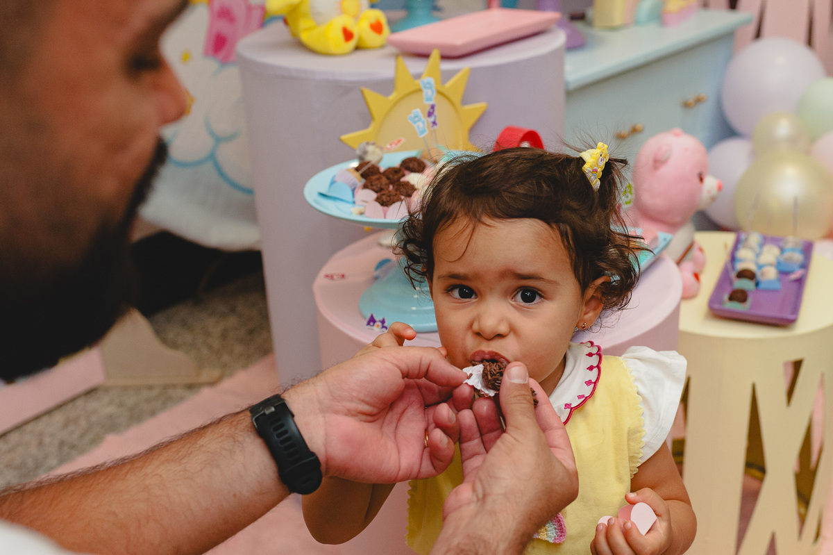 Pai oferecendo brigadeiro para a menina