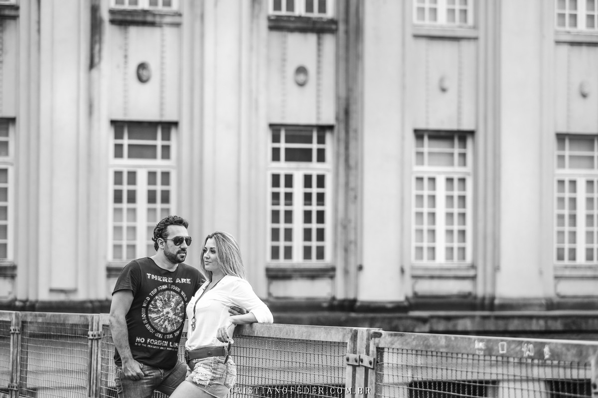 Casal de Noivos olhando o horizonte com o dia nublado no cais da cidade de Santos SP