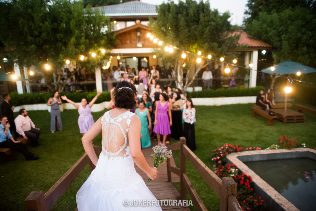 noiva jogando o buquê em espaço aberto ao ar livre
