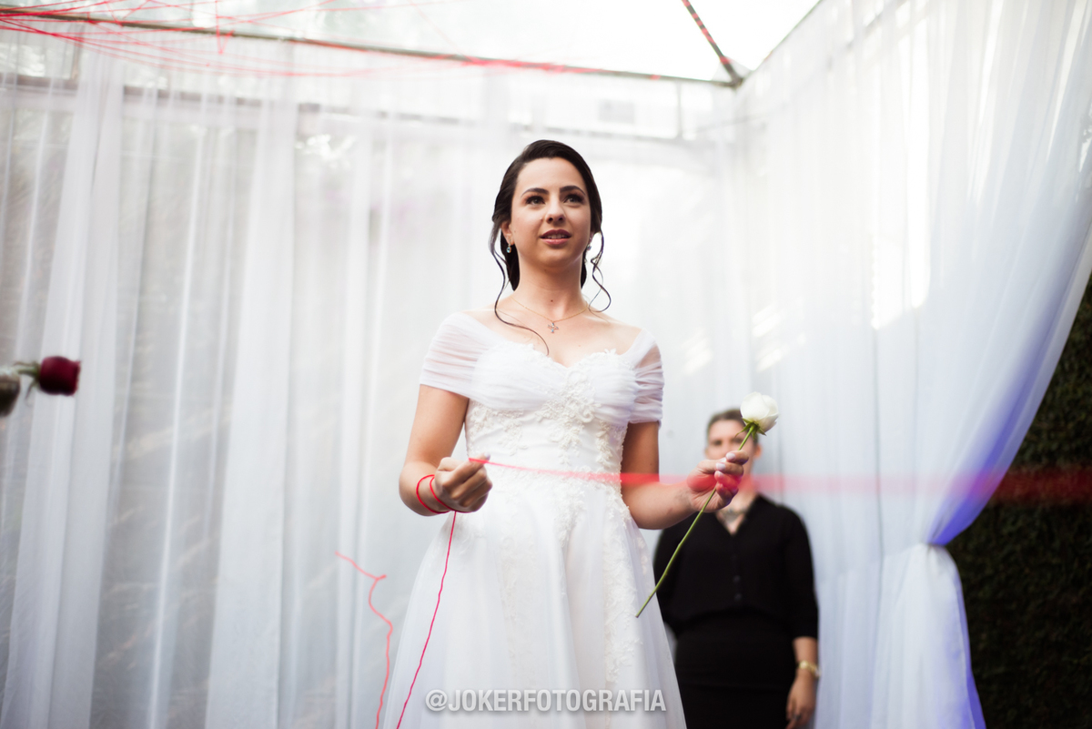 entrada dos noivos diferente e criativa, entrando pelas laterais e se unindo no centro por um fio vermelho