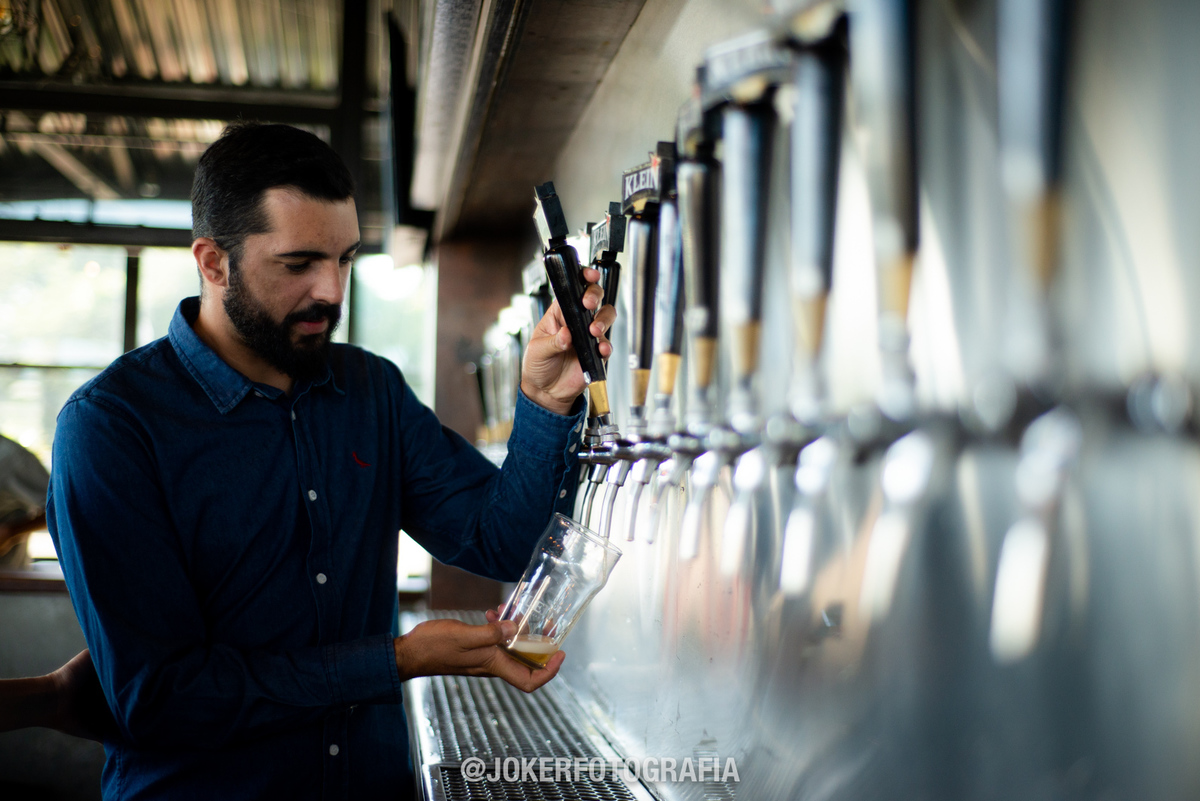 noivo brinda com copo de cerveja durante book de casamento
