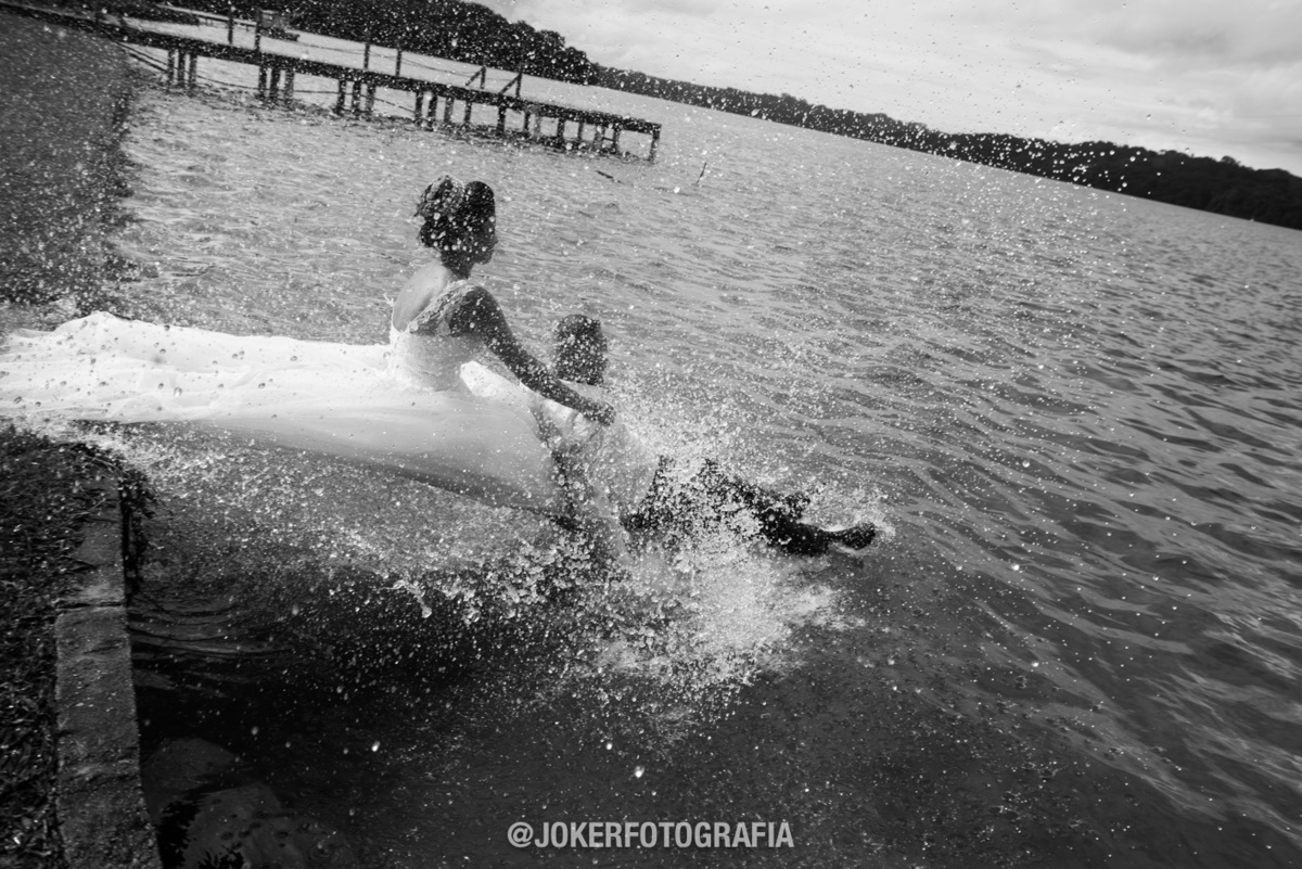 noiva entra no lago de vestido de noiva no dia do casamento noivo pula na piscina 