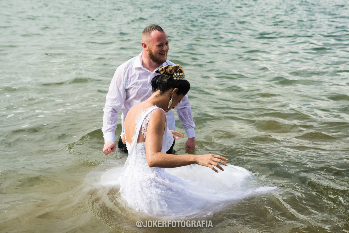 noiva pula no lago no dia do casamento vestida de noiva