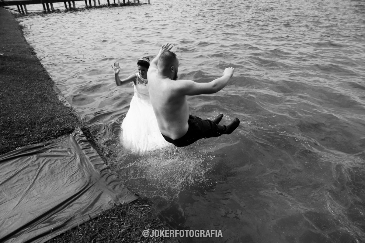 fotógrafo de casamento no laggus ve a noiva pulando na água de vestido