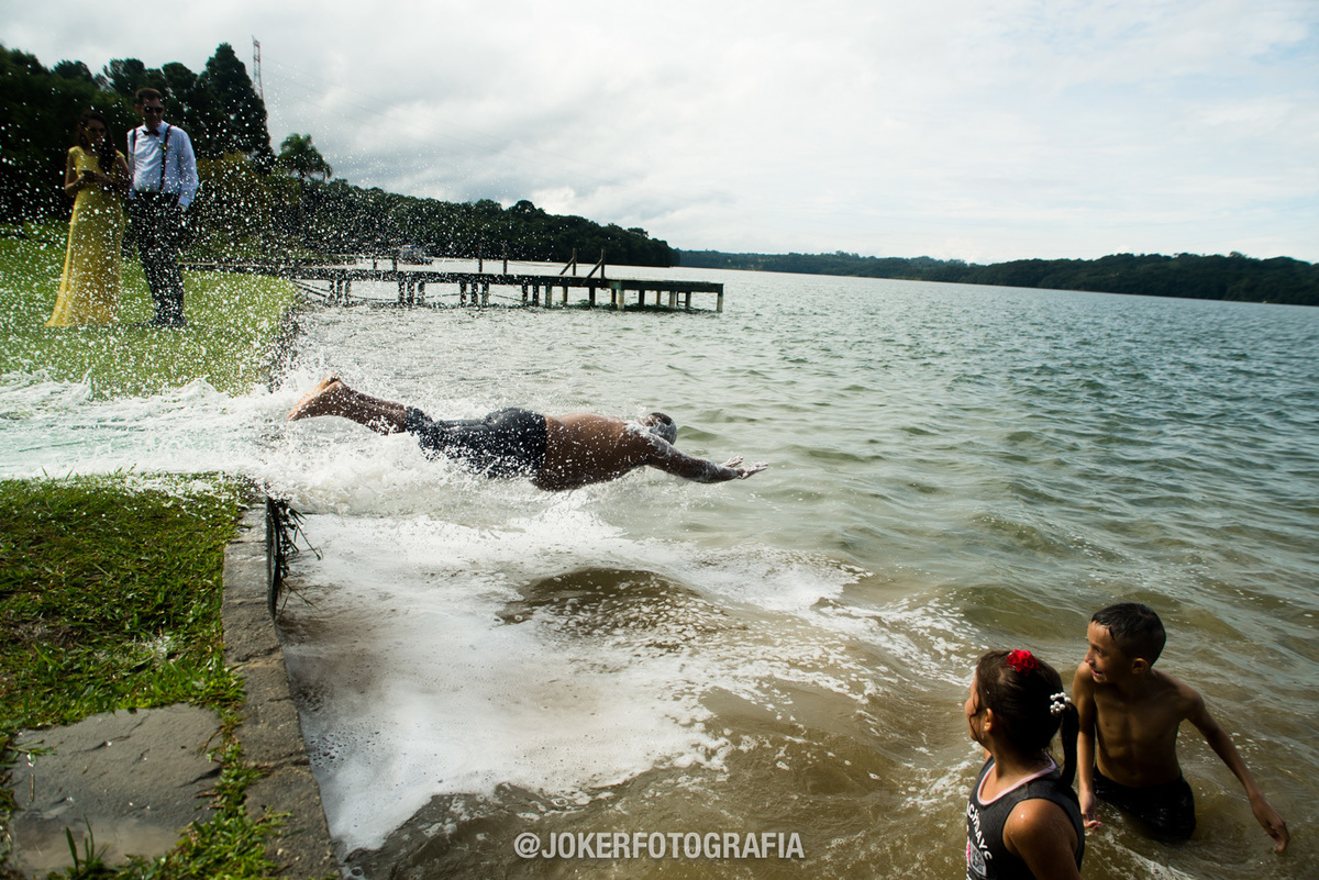 fotógrafo registra o noivo pulando no lago no dia do casamento 
