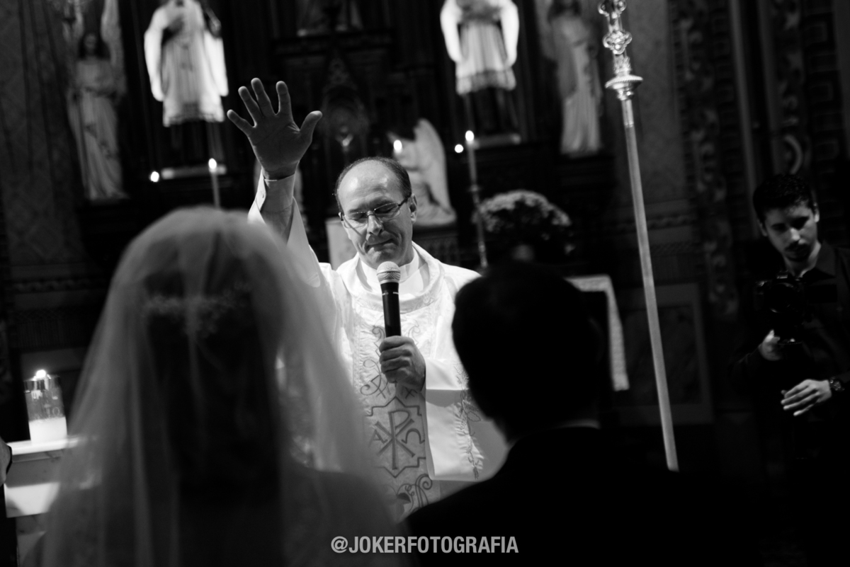 fotografia preto e branco mostra a benção do padre durante o casamento
