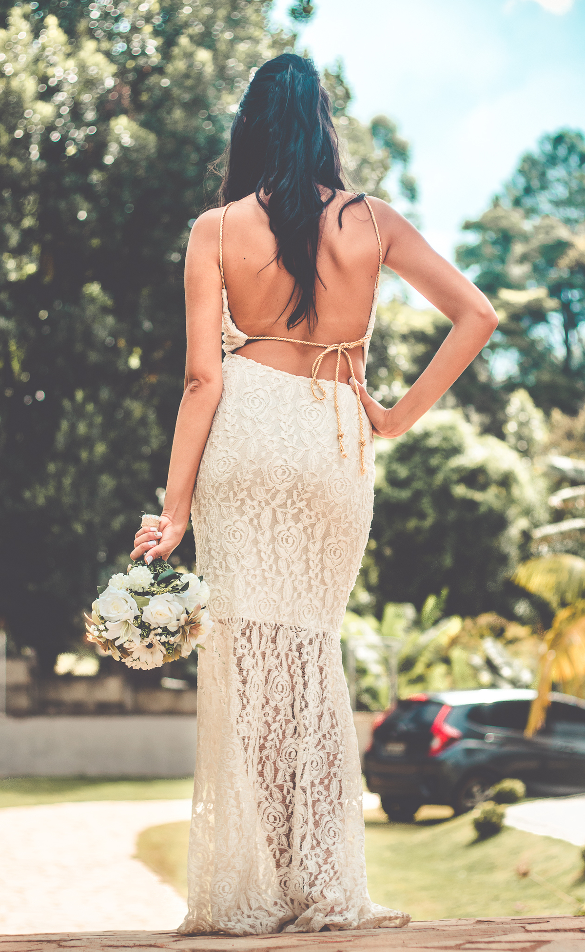 Foto das costas da noiva com buquê