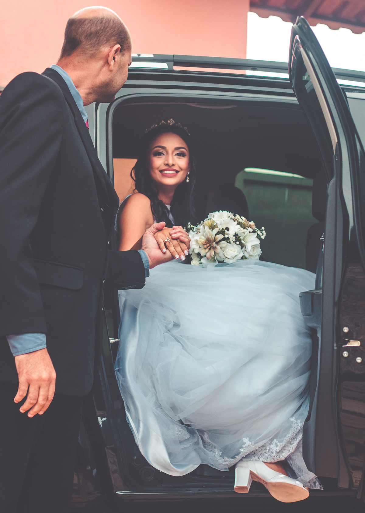 Foto de noiva no carro com bouquet e pai da noiva