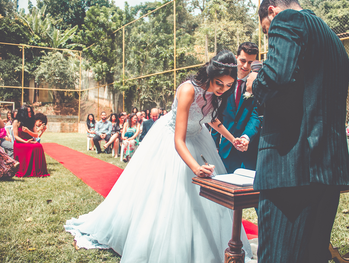 Foto da noiva assinando na cerimônia