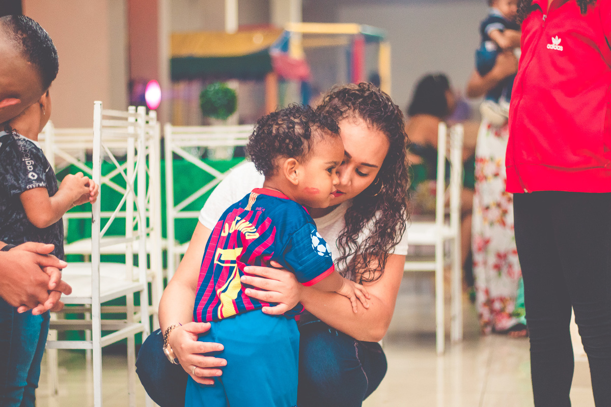 criança vestida de jogador de futebol em festa infantil brincando 