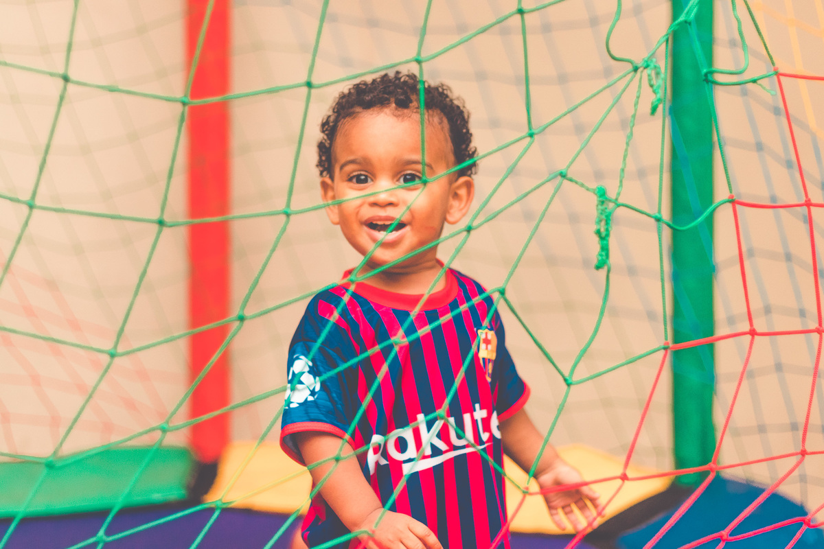 criança vestida de jogador de futebol em festa infantil brincando 