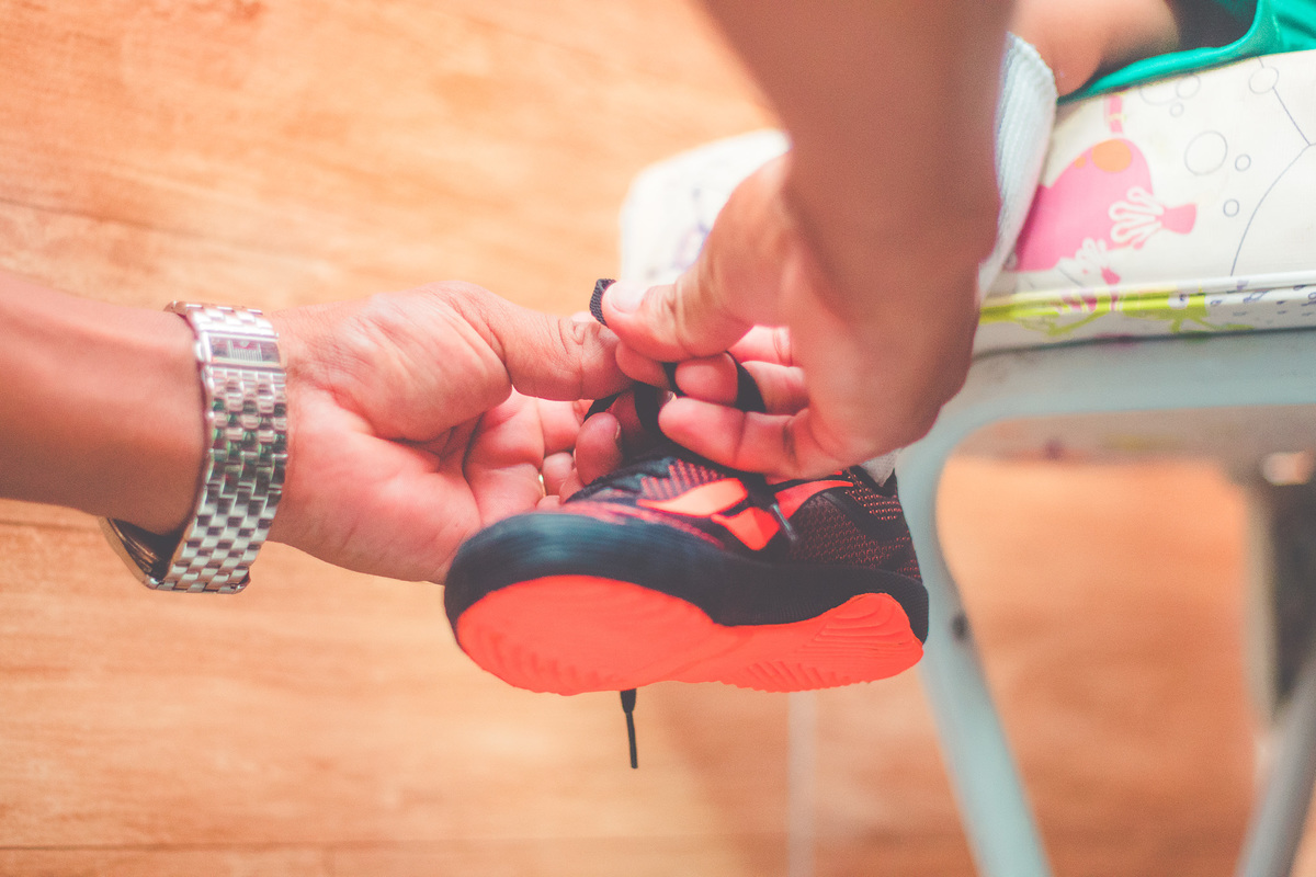 colocando uma chuteira em uma criança