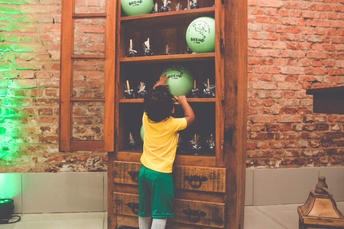criança vestida de jogador de futebol em festa infantil brincando 
