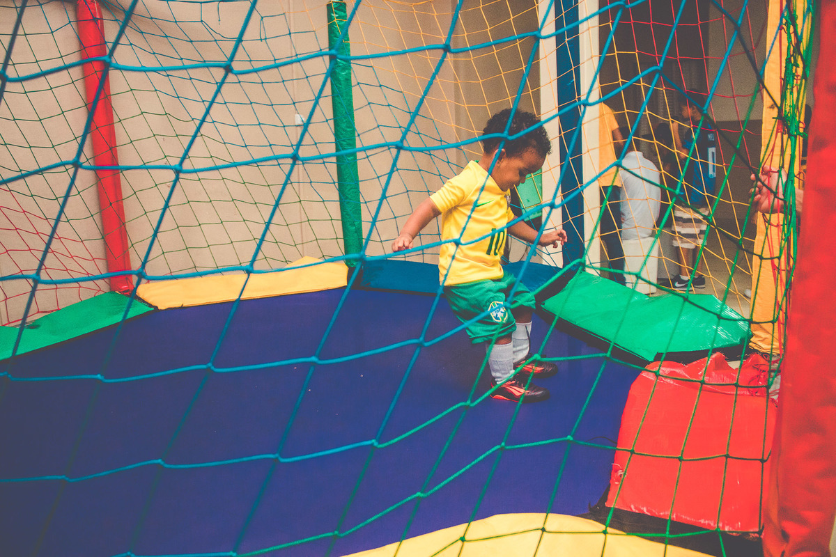 criança vestida de jogador de futebol em festa infantil brincando 