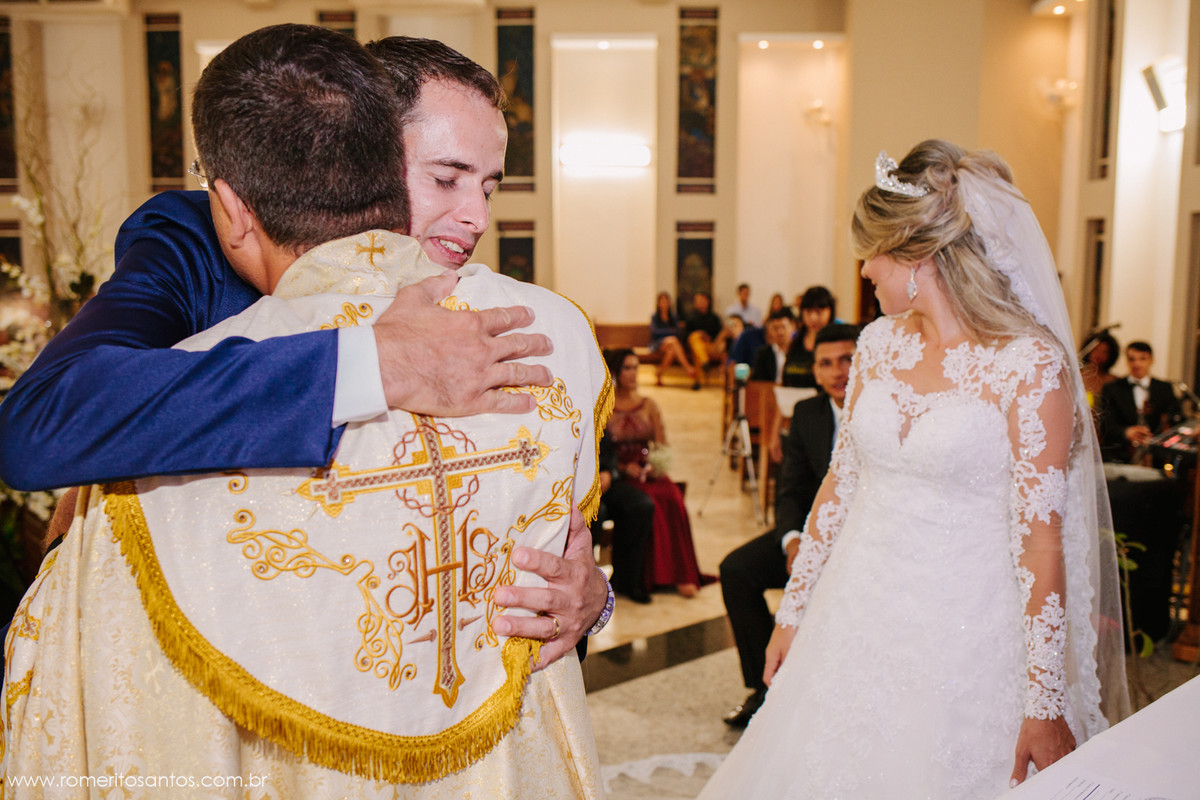 abraço apertado do noivo ao padre que acabou de realizar o seu casamento
