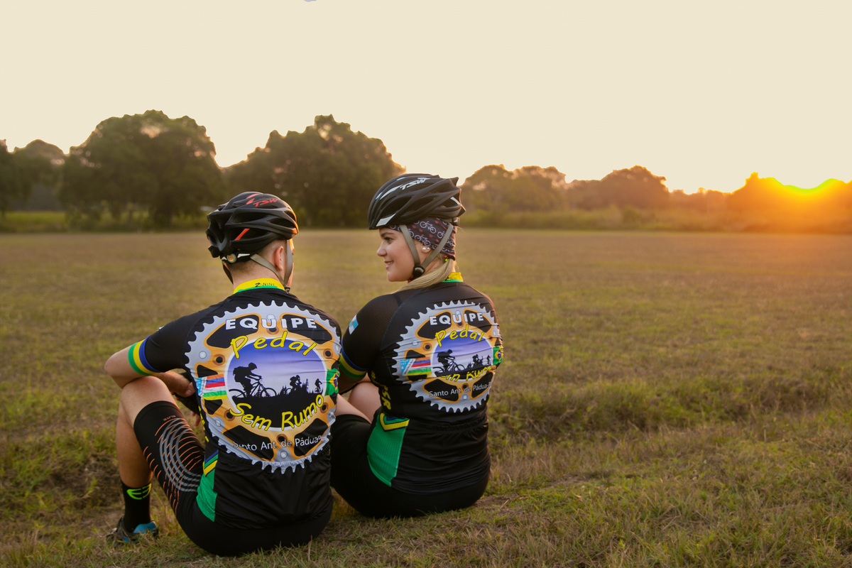 casal de noivos ciclistas se olhando durante ensaio pré-casamento no por do sol em santo antônio de pádua no rio de janeiro