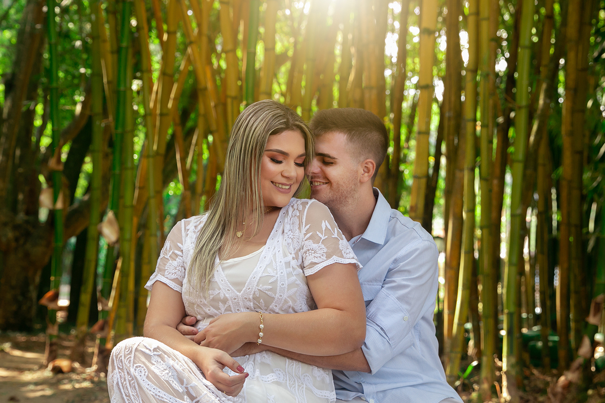 Noivo e noiva abraçados sorrindo debaixo do bambuzal no por do sol no Country Club em Nova Friburgo - RJ