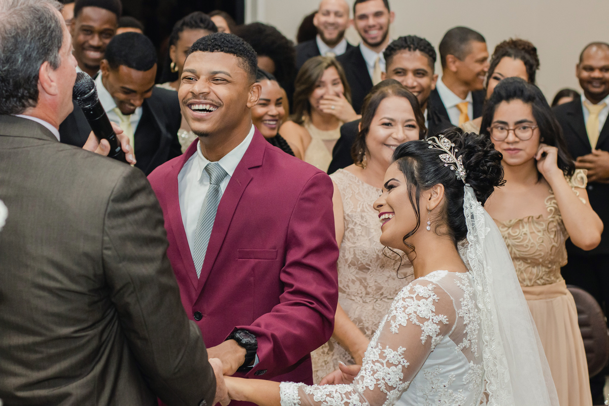 Noivos sorrindo ao lado das madrinhas de vestido dourado no momento da cerimônia em casamento na igreja Metodista Central em Pádua. RJ