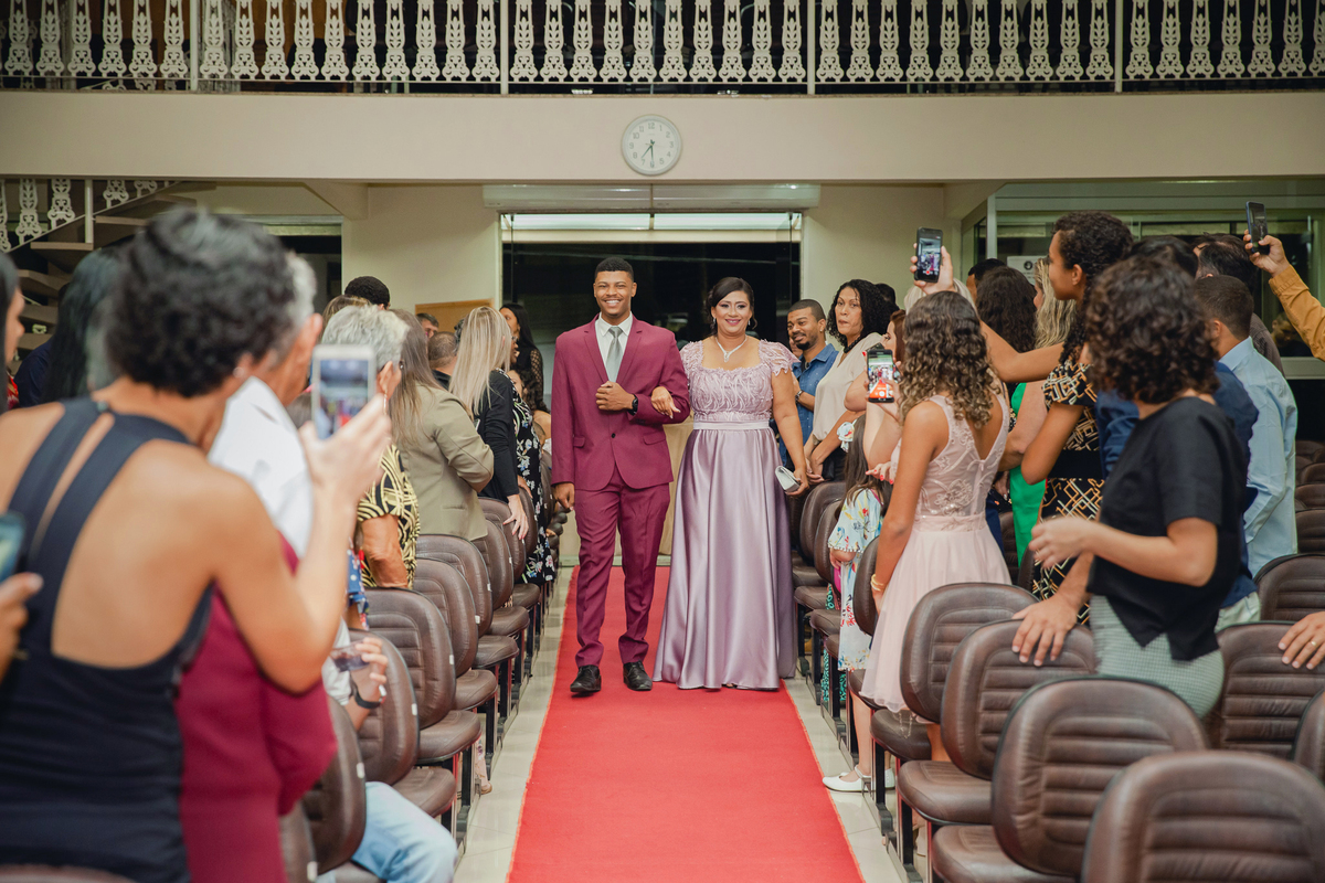 Noivo de terno vinho entrando na igreja com sua mãe em casamento na igreja Metodista Central em Santo Antonio de Pádua interior do Rio de Janeiro.