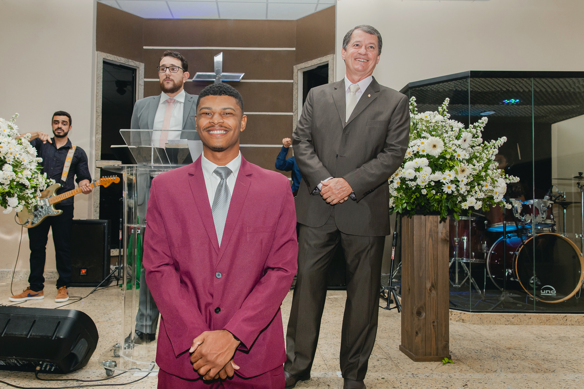 Noivo de terno vinho sorrindo aguardando a entrada da noiva em casamento na igreja Metodista Central em Santo Antonio de Pádua RJ.