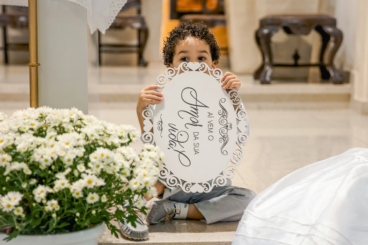 Pagem durante casamento na Paróquia de São José  de Leonissa em Itaocara no Rio de Janeiro brincando a plaquinha aí vem o amor da sua vida.