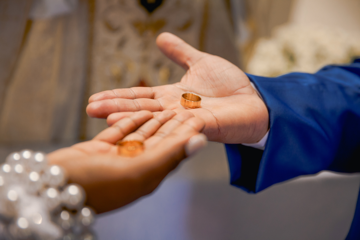 Noivos segurando as alianças durante casamento na igreja Paróquia de São José de Leonissa em Itaocara no Rio de Janeiro