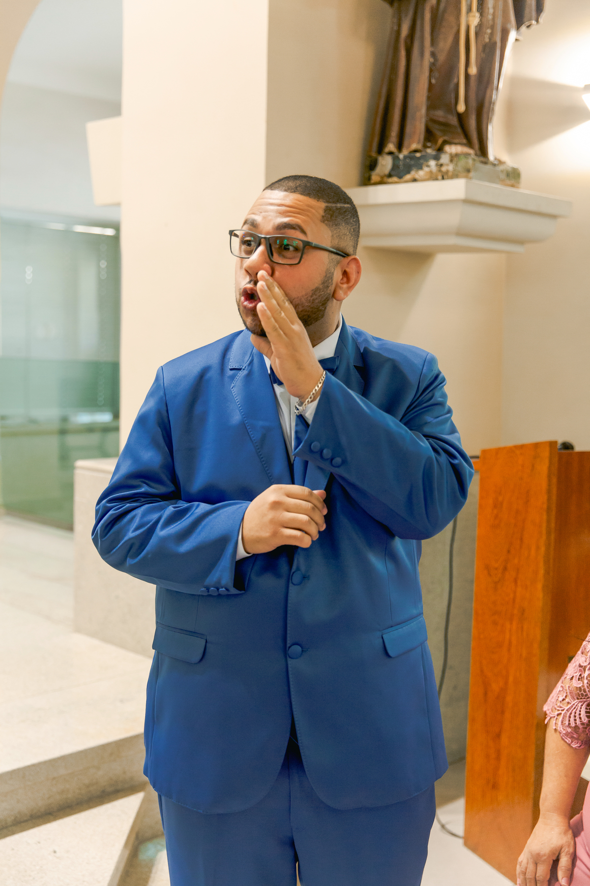 Noivo de terno azul dentro da igreja sorrindo aguaradando a noiva entrar na igreja em casamento na igreja Paróquia de São José de Leonissa em Itaocara no Rio de Janeiro.