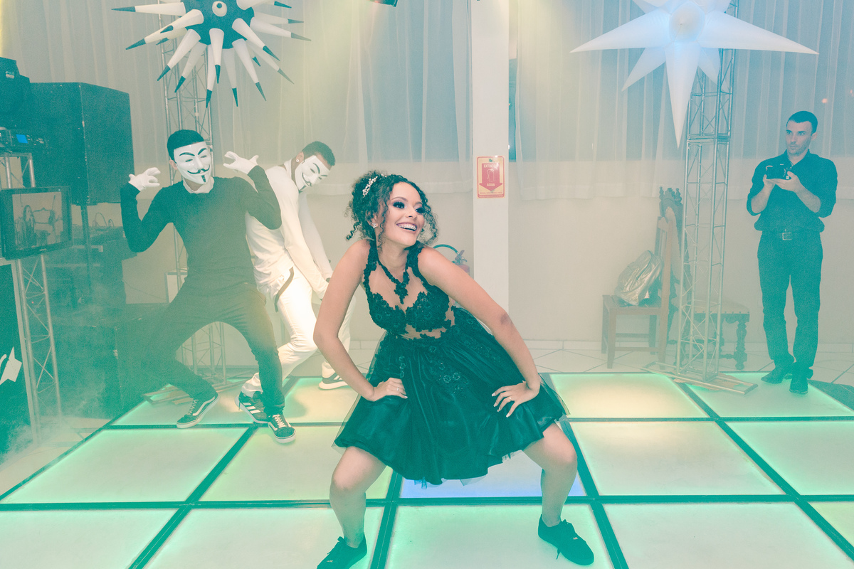 Debutante linda com vestido preto e curto e tênis dançando na pista de dança com mascarados durante sua festa de 15 anos  em Santo Antônio de Pádua no interior do Rio de Janeiro.