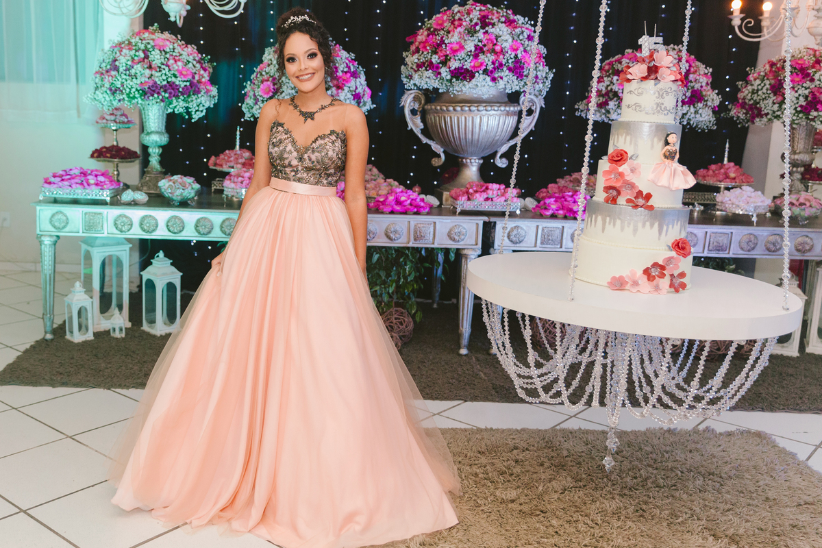 Aniversariante de 15 anos com seu vestido lindo preto e rosê na decoração de sua festa com bolo suspenso e e cortina preta com led em festa realizada em Santo Antônio de Pádua no RJ.