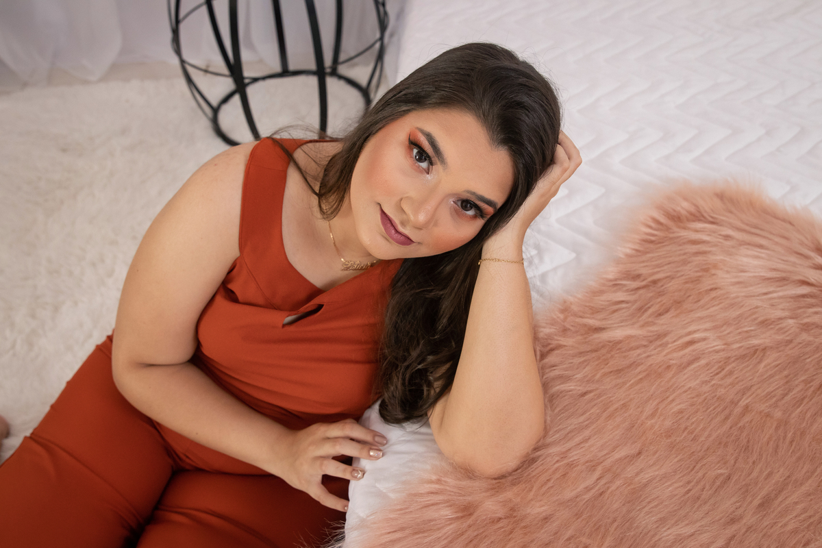 Ensaio feminino de 18 anos em estúdio, com cenário de cama, make perfeita e com balões rosê e na cor pessêgo em Santo Antônio de Pádua RJ