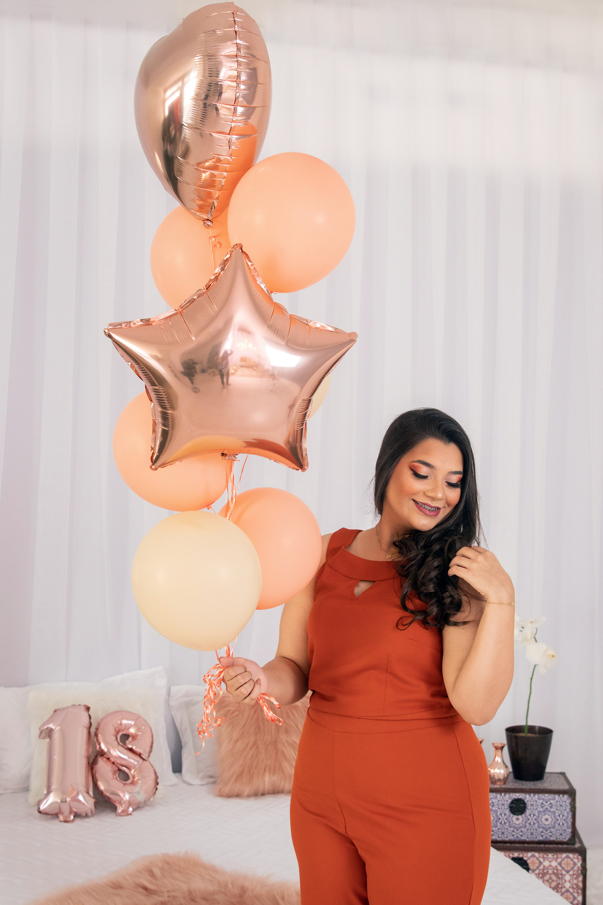 Ensaio feminino de 18 anos em estúdio, com cenário de cama, make perfeita e com balões rosê e na cor pessêgo em Santo Antônio de Pádua RJ