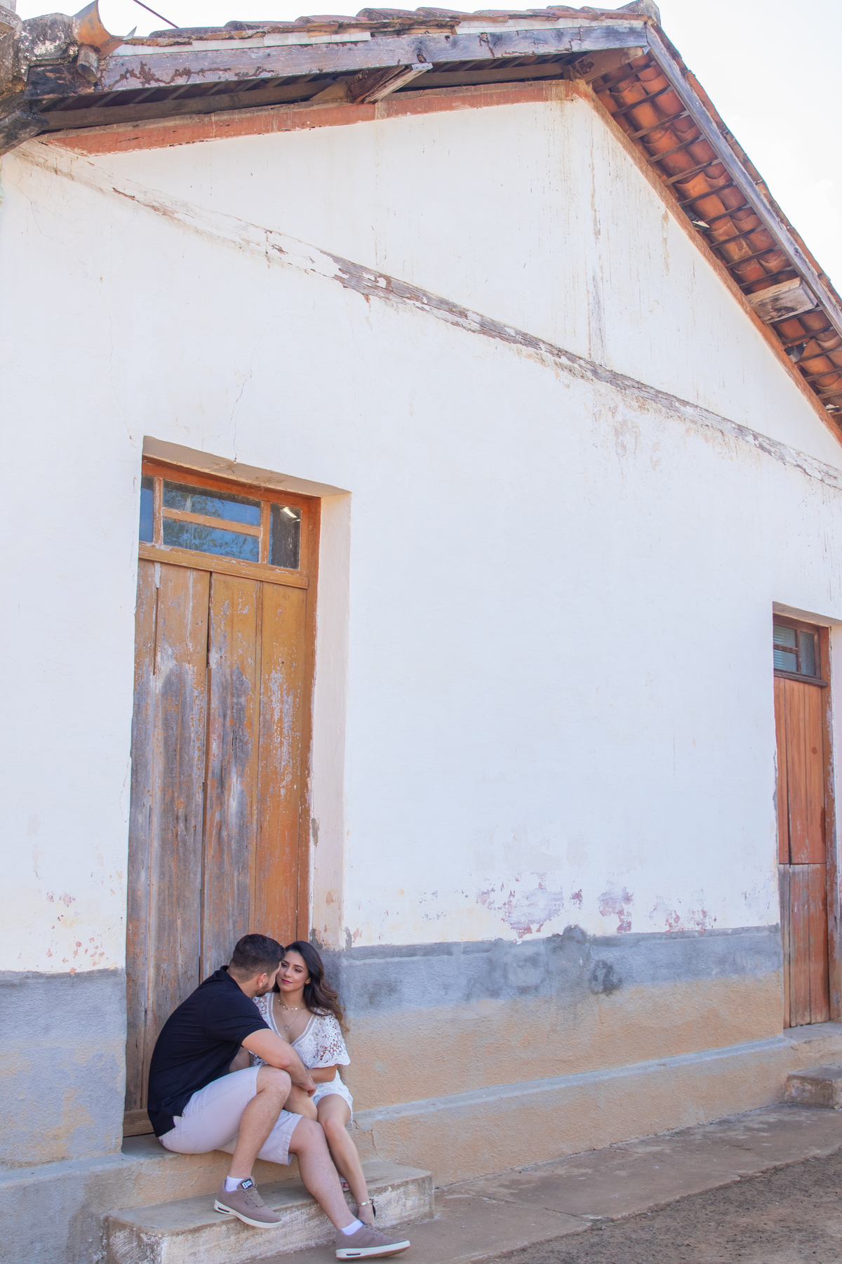 Casal abraçados e felizes, sentado perto de uma casa velha em Santo Antônio de Pádua no Rio de Janeiro.