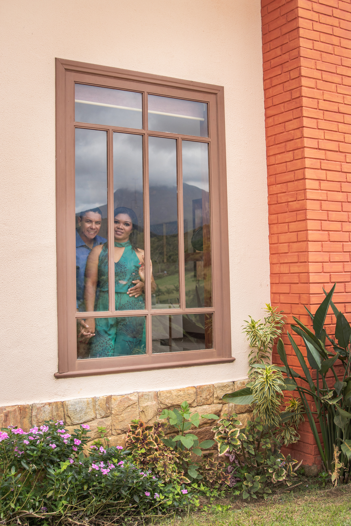 Ensaio Pré Wedding em Teresópolis em uma casa linda com uma vista maravilhoso e muitas flores e uma janela enorme e os noivos estavam na janela em Santo Antônio de Pádua no Rio de Janeiro.