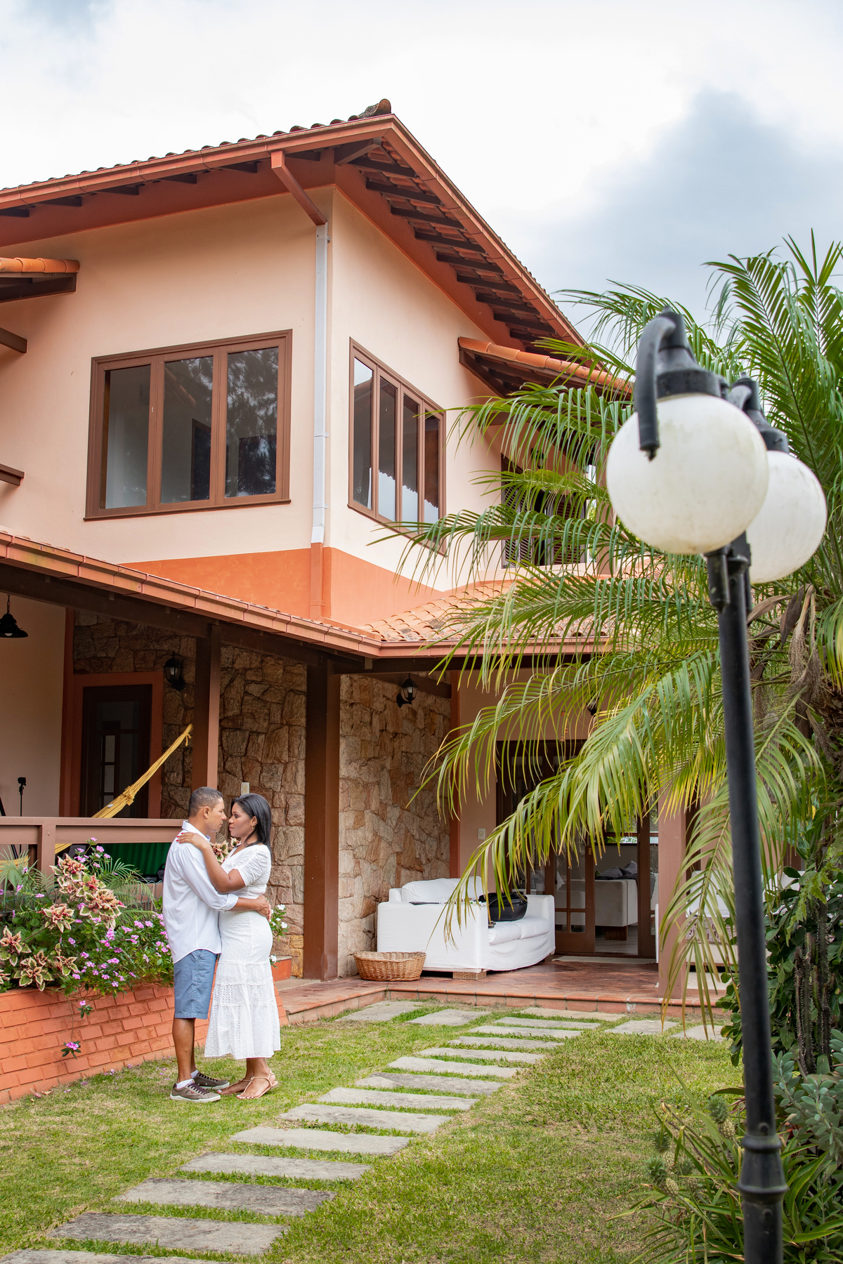 Ensaio pre casamento com tempo nublado na serra de Teresópolis, noiva e noivo com roupas brancas em uma casa linda com muito verde e muitas flores e hortênsias azuis em Pàdua RJ.
