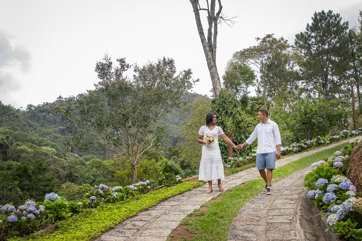 Noivos em seu ensaio Pré Wedding com tempo nublado na serra de Teresópolis, noiva e noivo com roupas brancas em uma casa linda com muito verde e muitas flores e hortênsias azuis em Pàdua RJ.