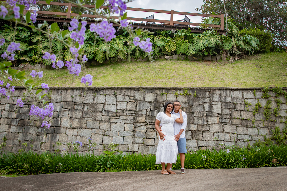 Noivos apaixonados em seu ensaio pre casamento em dia nublado na serra de Teresópolis, noiva e noivo com roupas brancas em uma casa linda com muito verde e muitas flores e hortênsias azuis em Pàdua RJ.
