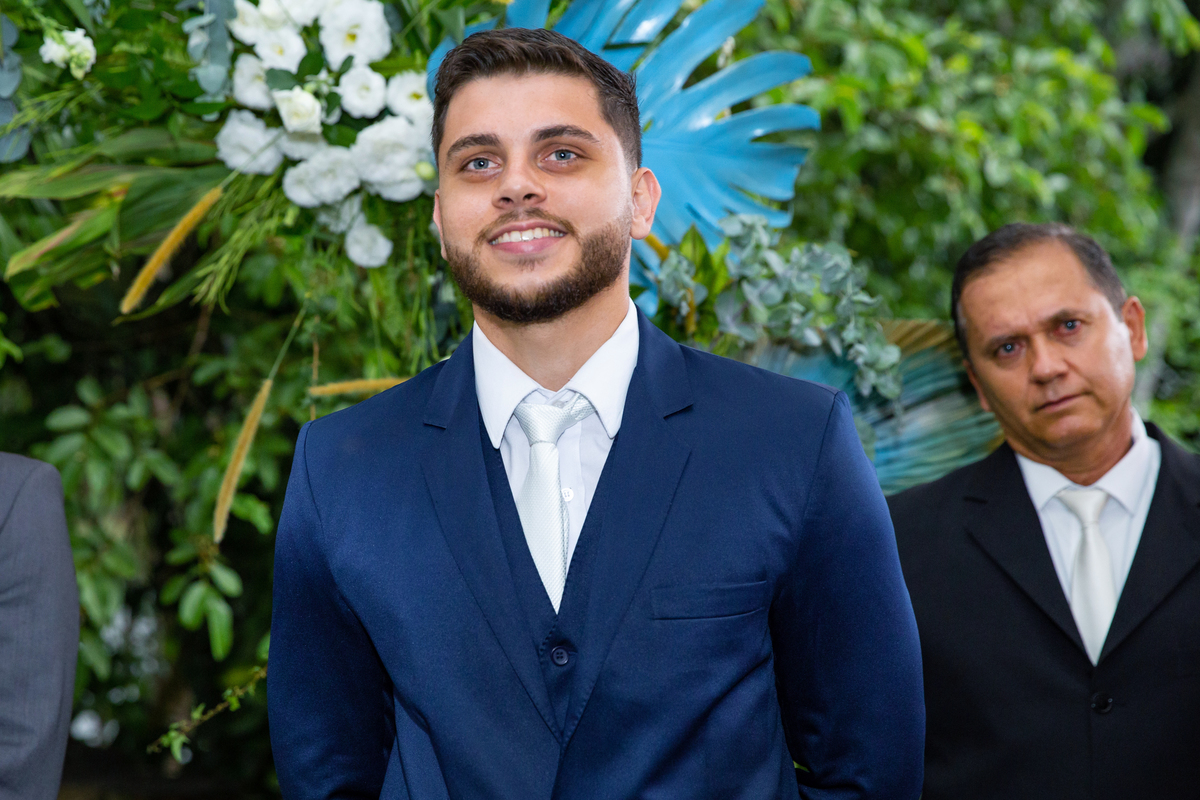 Noivo muito feliz e emcionado em seu terno azul olhando  a noiva entrar na cerimônia do seu casamento em Pádua no interior do Rio de Janeiro.