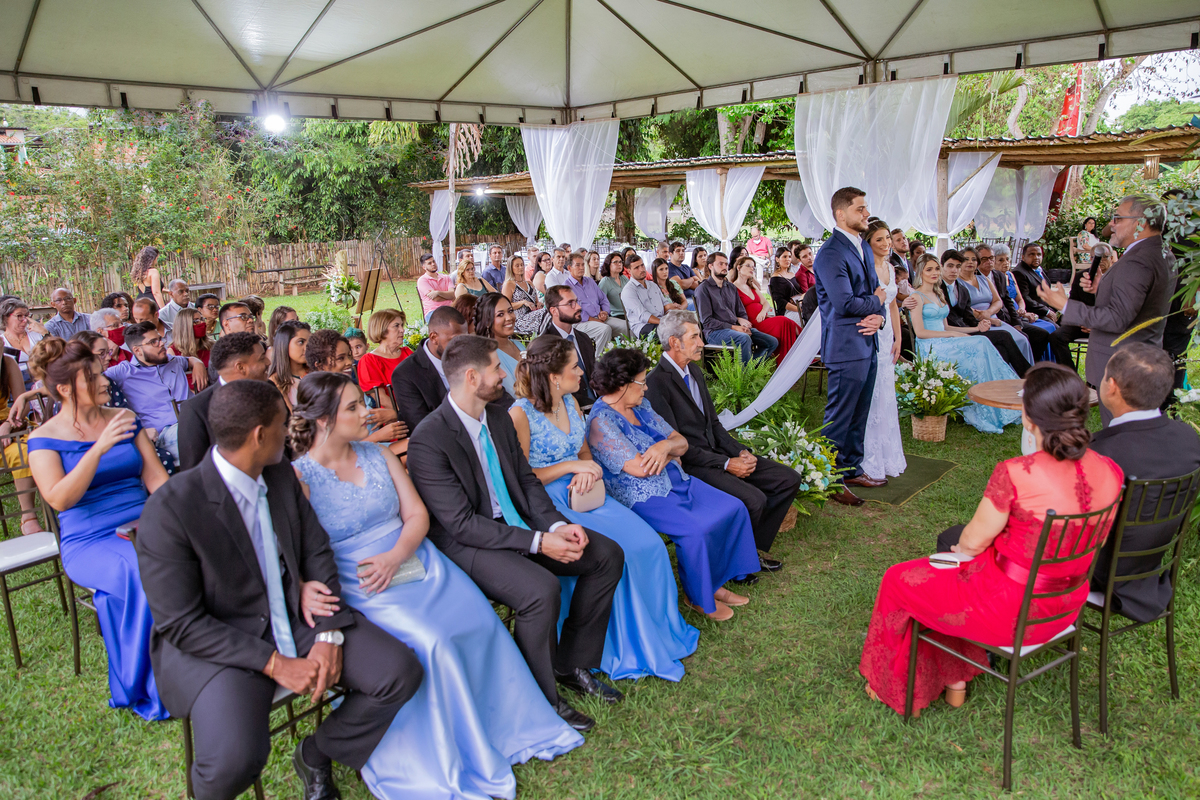 Padrinhos e familiares sorrindo durante cerimonia de casamento ao ar livre em Pádua no interior do Rio de Janeiro.