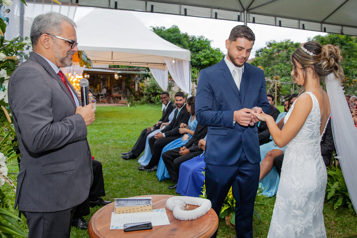 Noivo colocando a aliança na noiva  durante o casamento ao ar livre. Casamento feito pelo pastor Márcio da primeira igreja de Pádua, interior do Rio de Janeiro.