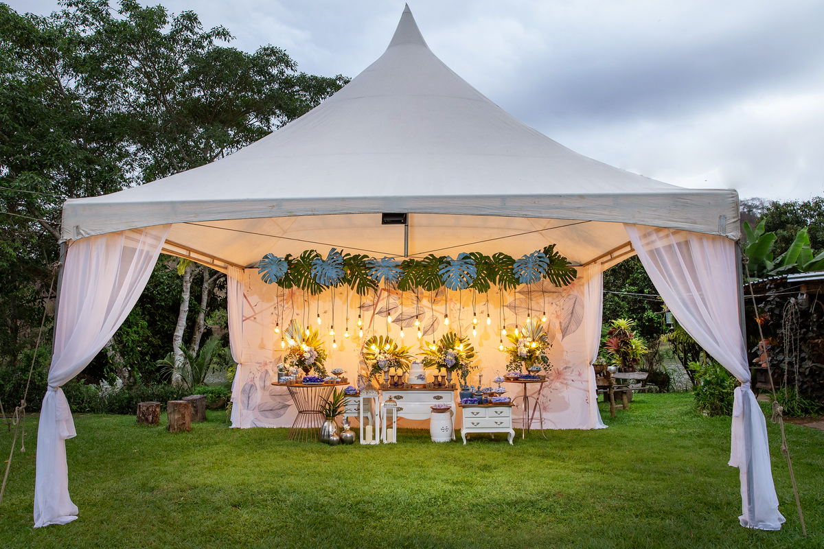 Fotos da decoração de um casamento lindo ao ar livre, decoração com muito verde e lâmpadas penduradas, doces em tons de azuis em Santo Antônio de Pádua - Rj.
