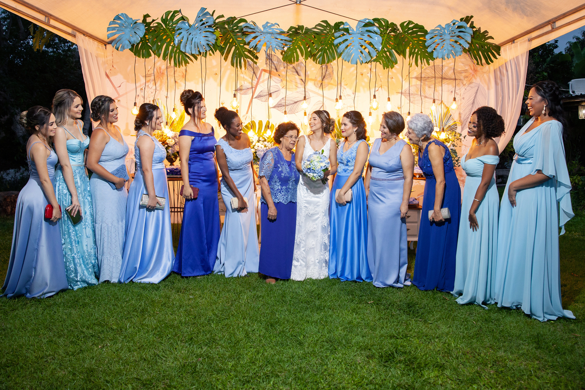 Madrinhas lindas vestidas com vestidos na cor azul olhando para noiva com buque com flores azul e branco durante festa de casamento em em Santo Antônio de Pádua - Rj.