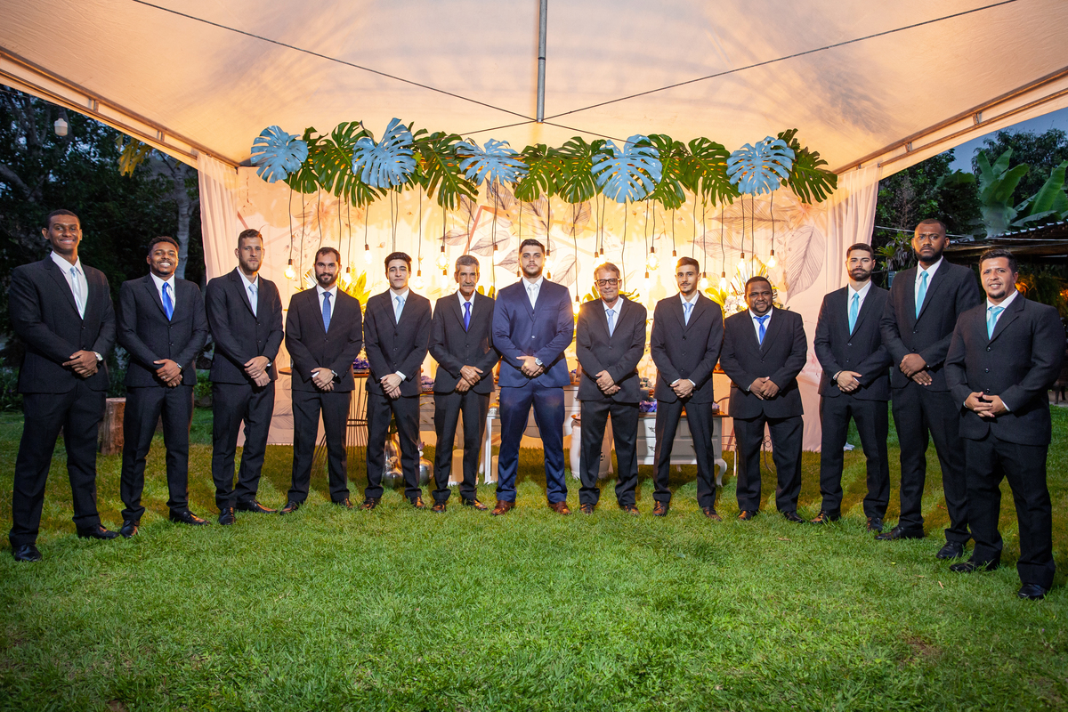 Padrinhos em volta do noivo durante festa de casamento ao ar livre em Santo Antônio de Pádua no Rio de Janeiro.