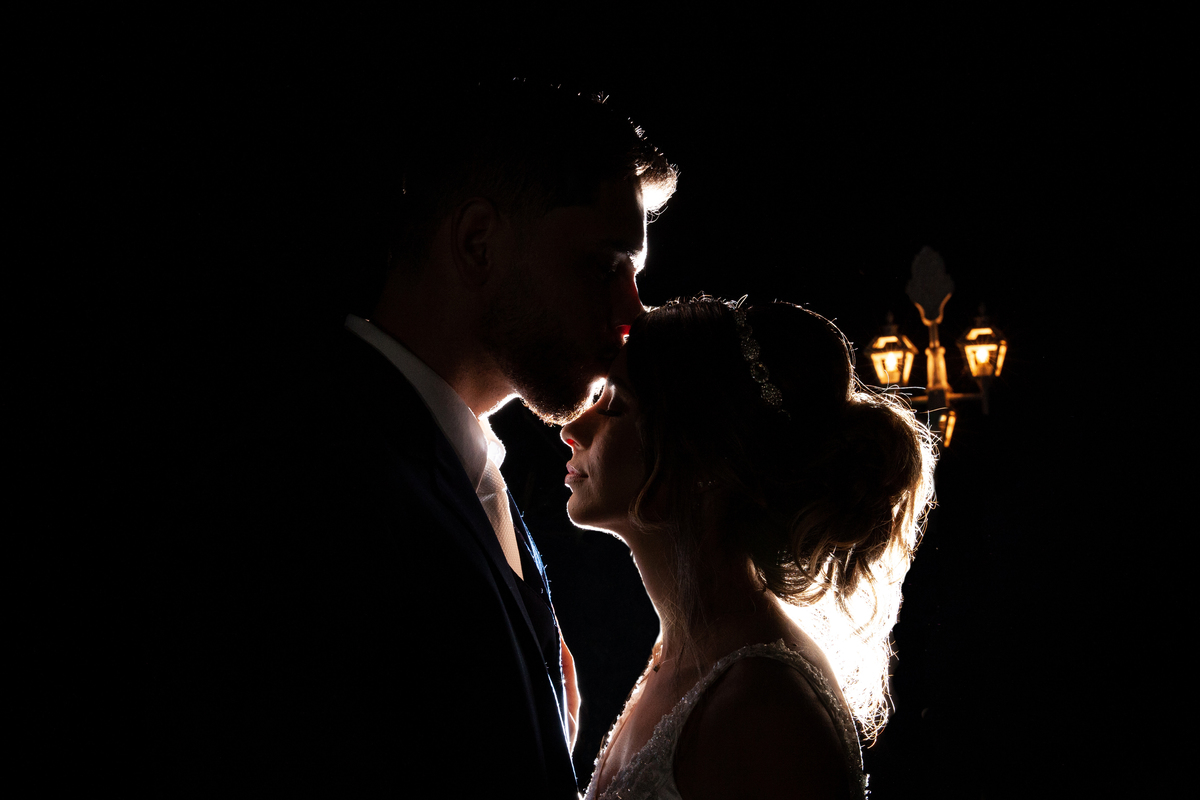Fotos dos noivos em contra luz, apenas silhueta no final da festa ao ar livre em cerimônia evangélica em Santo Antônio de Pádua - RJ.