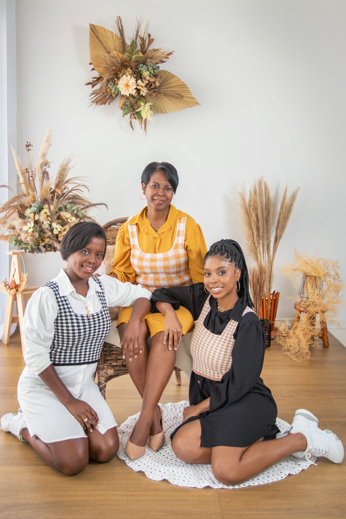 Ensaio Mãe e filhas com roupas combinando, em tons preto, branco e mostarda com coletes xadrez em um cenário Boho com capim dos pampas para o especial de dia das mães em nosso estúdio em Santo Antônio de Pádua no interior do Rio de Janeiro.
