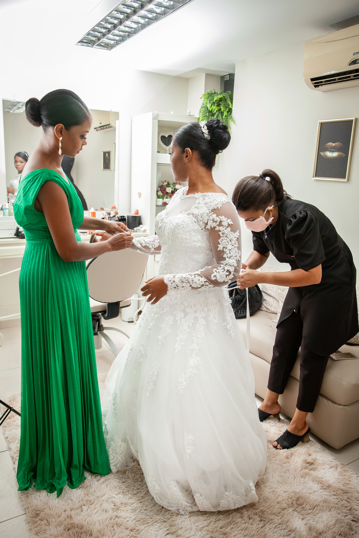 Making of da noiva no salão espaço f em Pádua. Noiva colocando o vestido e madrinha ajudando. Vestido lindo de renda, momentos antes do grande sim. Em casamento em Cambuci, interior do Rio de Janeiro.