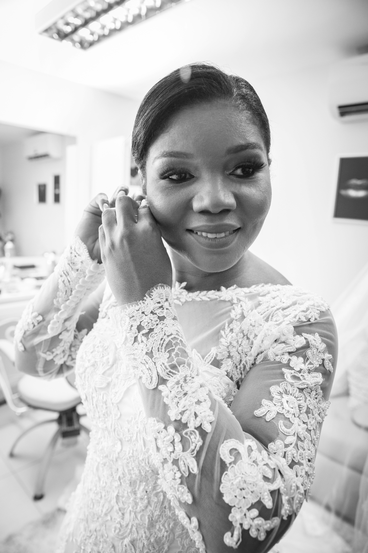 Making of da noiva no salão espaço f em Pádua. Noiva colocando o brinco em foto preta e branca. Vestido lindo de renda, momentos antes do grande sim. Em casamento em Cambuci, interior do Rio de Janeiro.