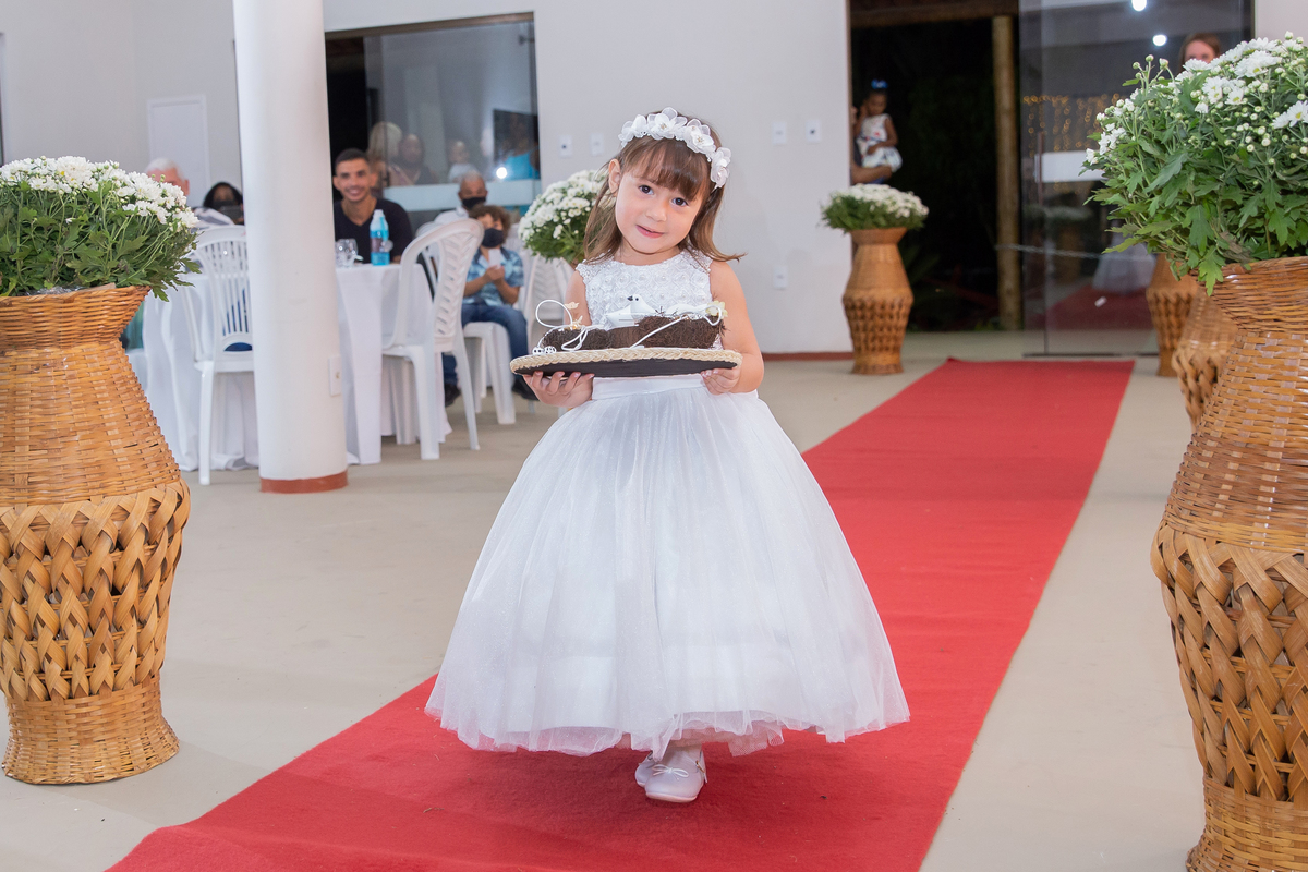 Dama entrando com as alianças em um lindo porta alianças feito de feltro com passaarinhos. Dama linda e sorrindo durante cerimônia evangélica em um casamento a noite em um sitio em Cambuci no interior do Rio de Janeiro.