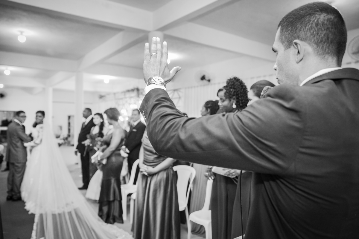 Noivos saindo da cerimônia de casamento sorrindo e felizes. Noiva com vestido de renda e véu lindo e noivo com terno cinza. casamento durante a noite em um sitio em Cambuci no interior do Rio de Janeiro. Foto preta e branca.