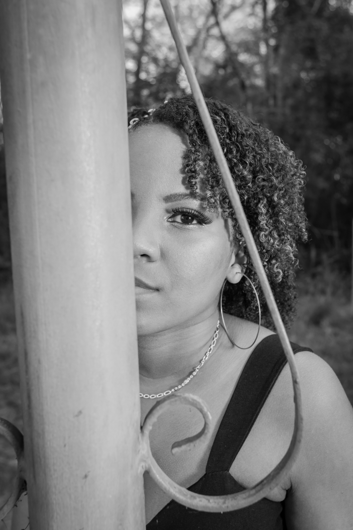 Aniversariante linda de 15 anos, com cabelo cacheado em um dia lindo com muito verde ao por do sol parque municipal de Miracema em seu ensaio de 15 Anos. No interior do Rio de Janeiro. Em foto preta e branca