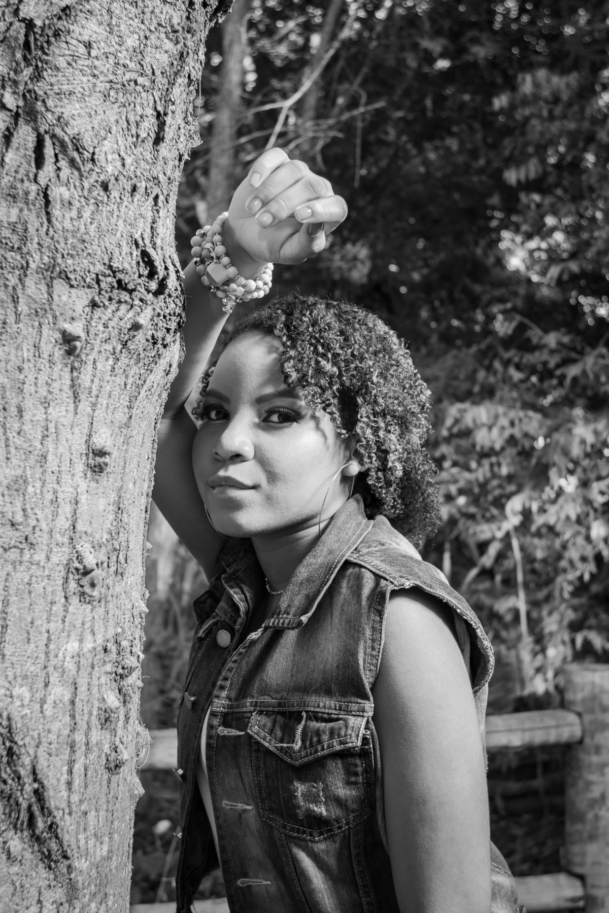 Aniversariante linda com jaqueta jeans em um campo florido com um céu azul perfeito no parque municipal de Miracema em seu ensaio de 15 Anos. No interior do Rio de Janeiro. Foto preta e branca